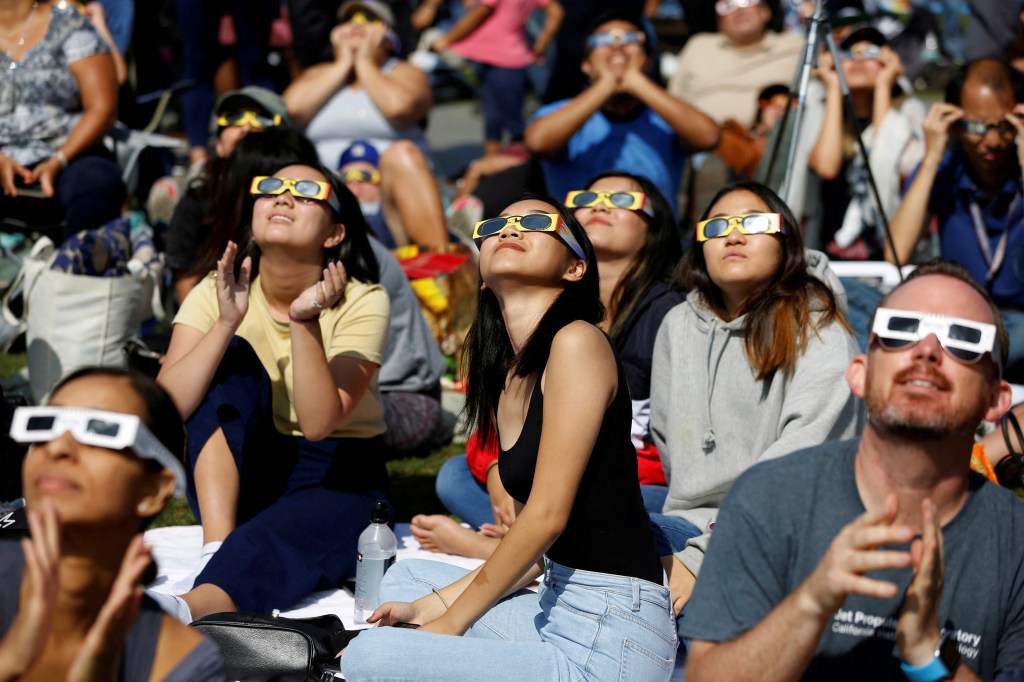 People watch the solar eclipse on the lawn of Griffith Observatory in Los Angeles, California, U.S., August 21, 2017. 