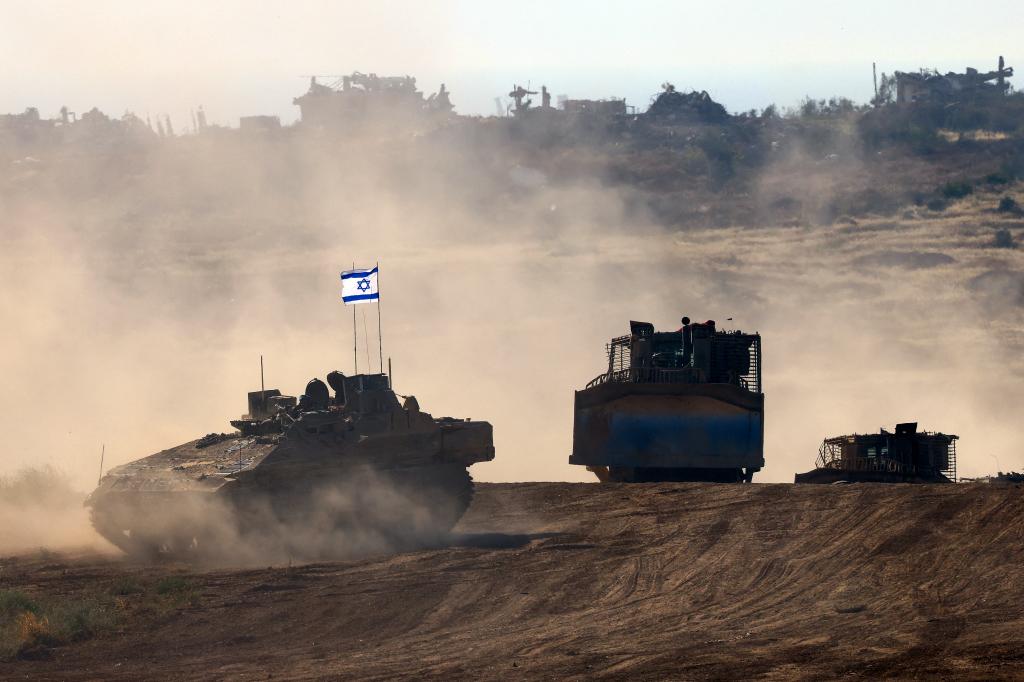 This picture taken from Israel's southern border with the Gaza Strip shows Israeli bulldozers behind an armoured vehicle rolling along the border with the Palestinian territory 