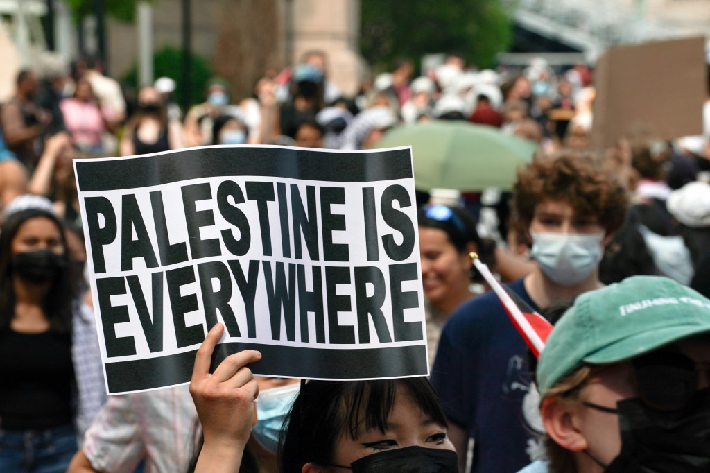 "Palestine Is Everywhere" sign held up by marching student