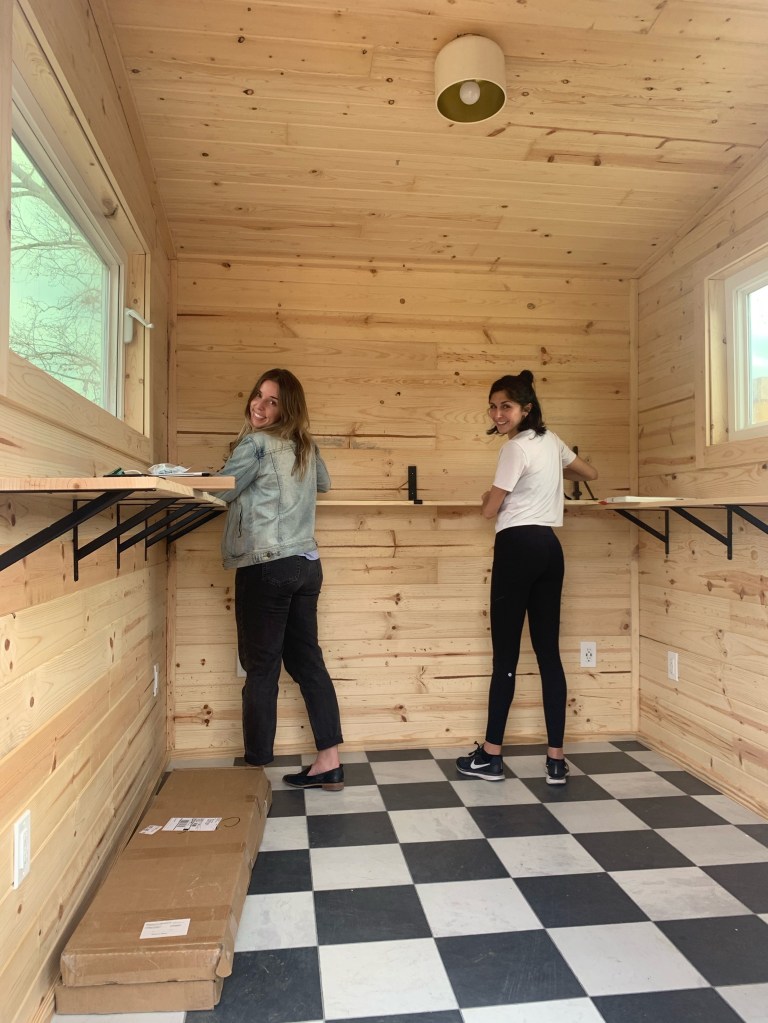 Stephanie Douglass and Kristina Modares, co-founders of a real estate agency, standing together in a room