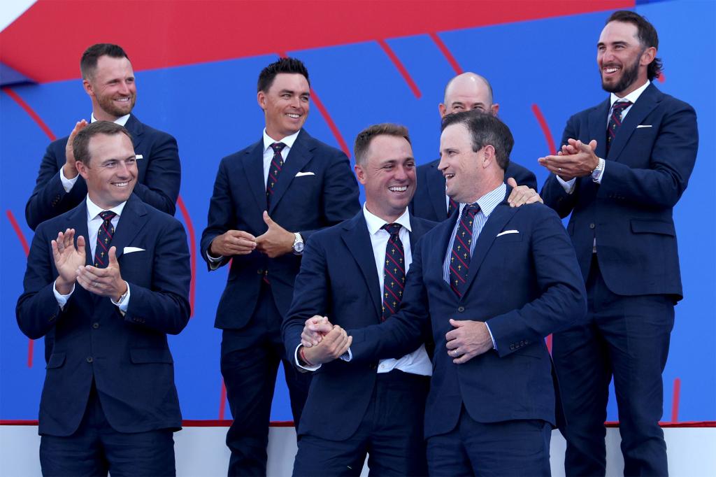 Justin Thomas embraces U.S. Ryder Cup captain Zach Johnson as fellow team members applaud in September 2023.