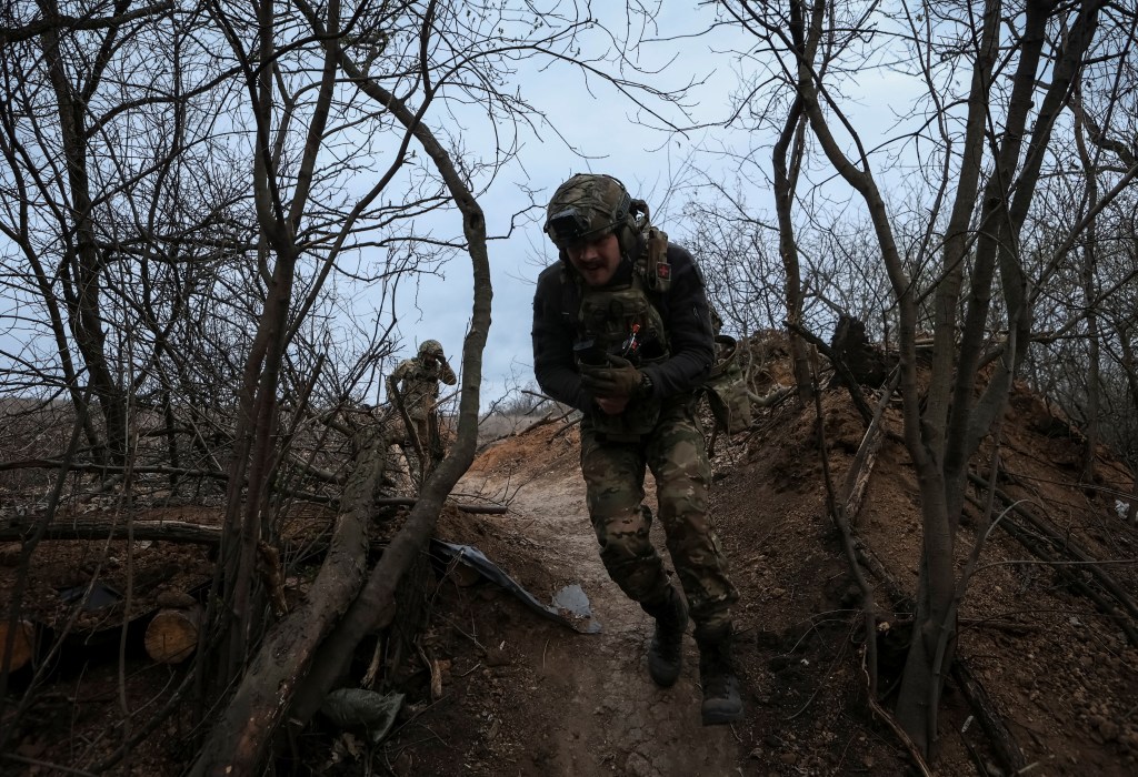 Servicemen of the 12th Special Forces Brigade Azov of the National Guard of Ukraine run at their positions at a frontline, amid Russia's attack on Ukraine.