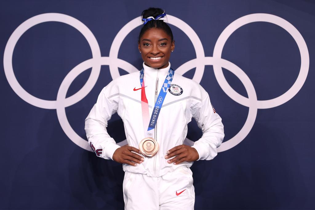 Simone Biles poses with the bronze medal following the Women's Balance Beam Final  on August 3, 2021.