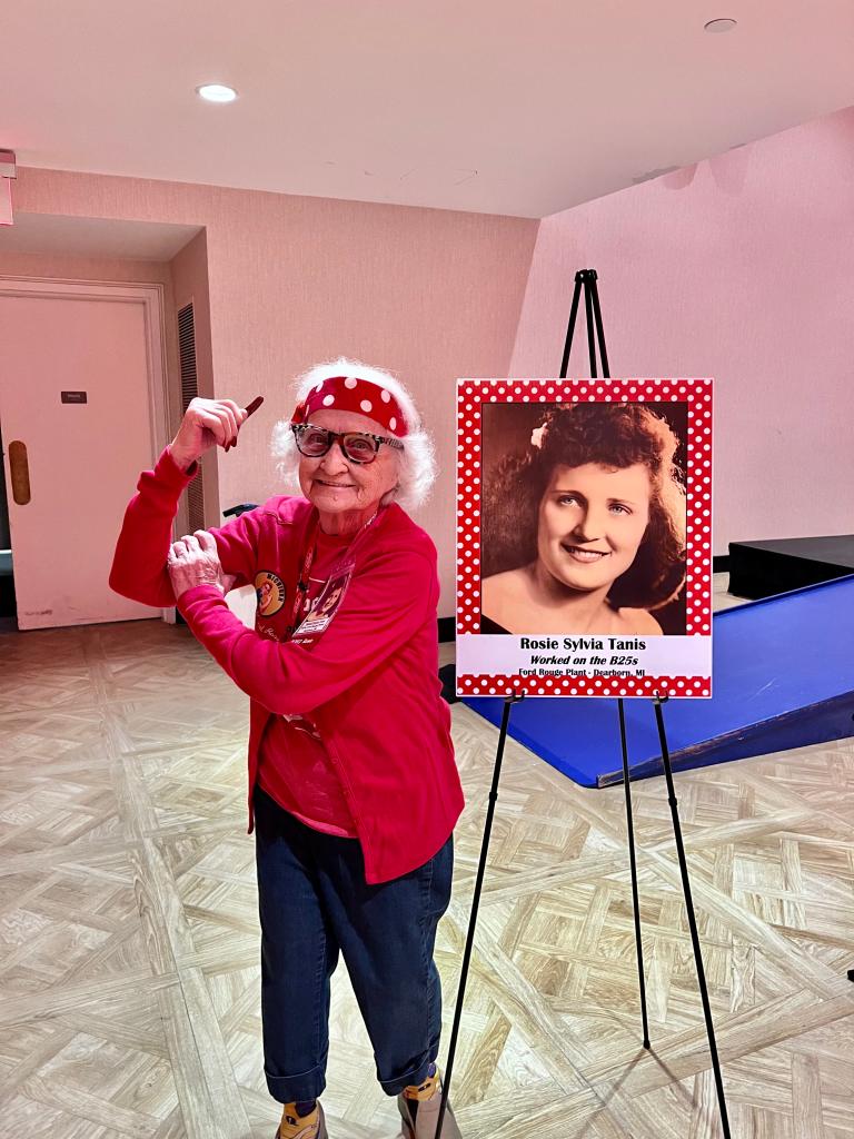 Sylvia Tanis flexing her arm muscle, a la Rosie the Riveter, next to a photo of herself as a young woman