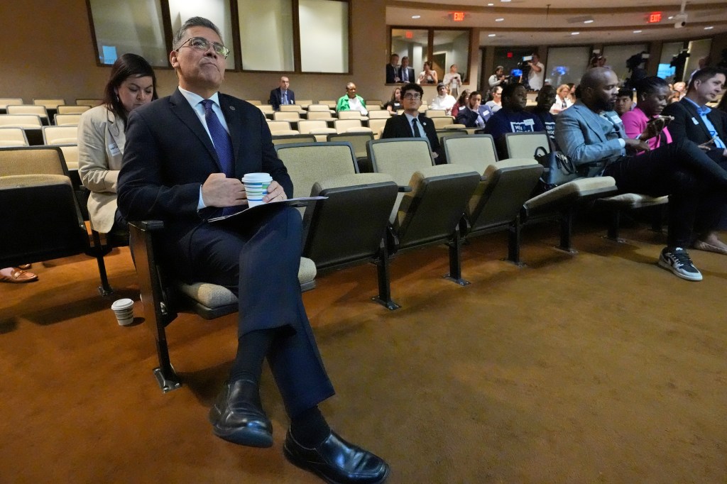 Department of Health and Human Services Secretary Xavier Becerra, left, waits to speak to a meeting of the Democratic Steering & Policy Committee Field Hearing on Reproductive Freedom, Tuesday, April 2, 2024, in Fort Lauderdale, Fla. 