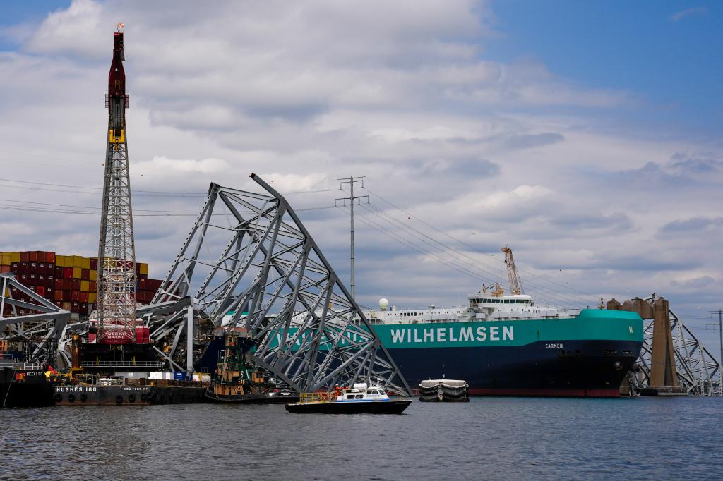 Cargo ship moves past Baltimore Key Bridge wreckage.