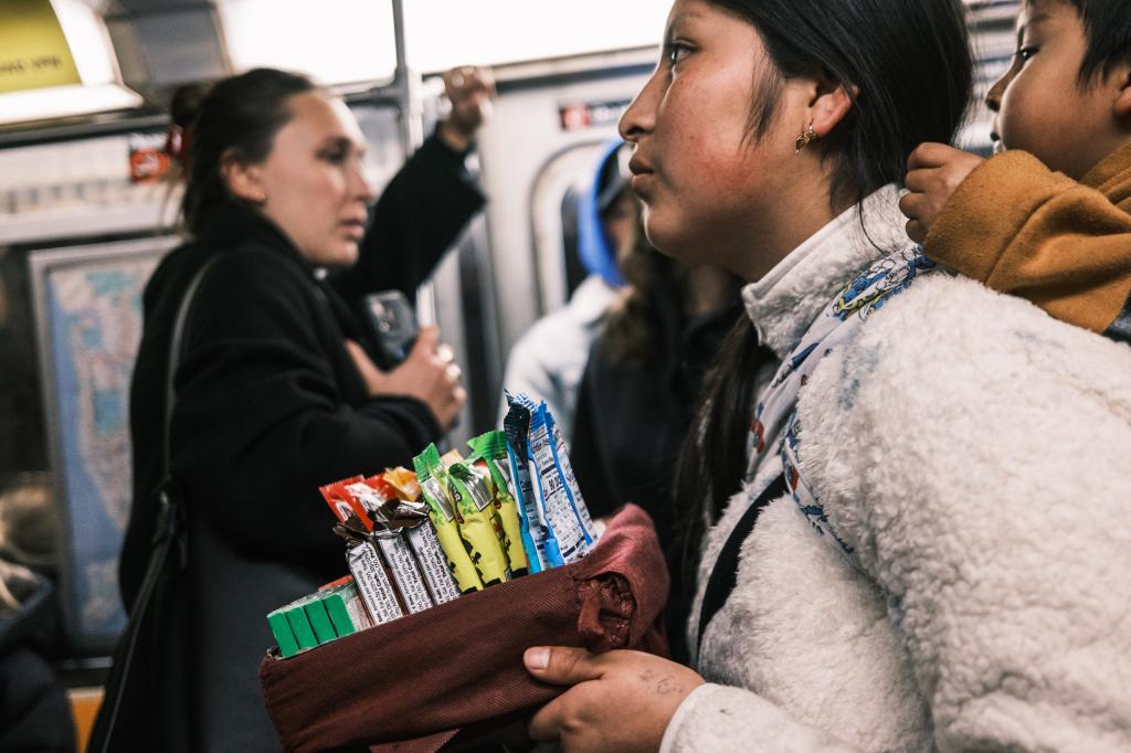 Migrant mom and son selling candy in the subways. 