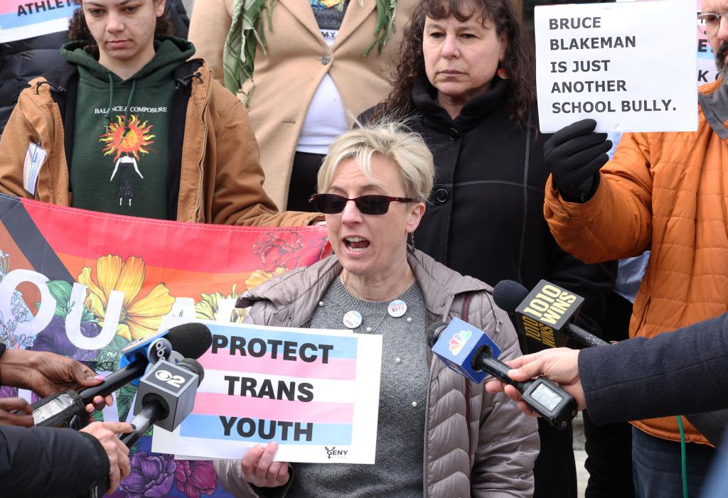 Transactivist Jennifer Molloy, supporting Executive Director Juli Grey-Owens with Gender Equality New York, speaking at a gathering outside Theodore Roosevelt Building in response to proposed transgender sports policy changes in Nassau County, New York