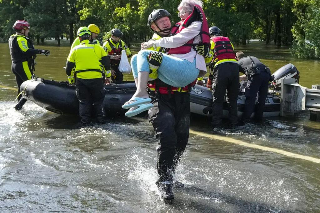 A man carrying a woman through a flooded area in East Texas with Paola Binetti among the rescue workers