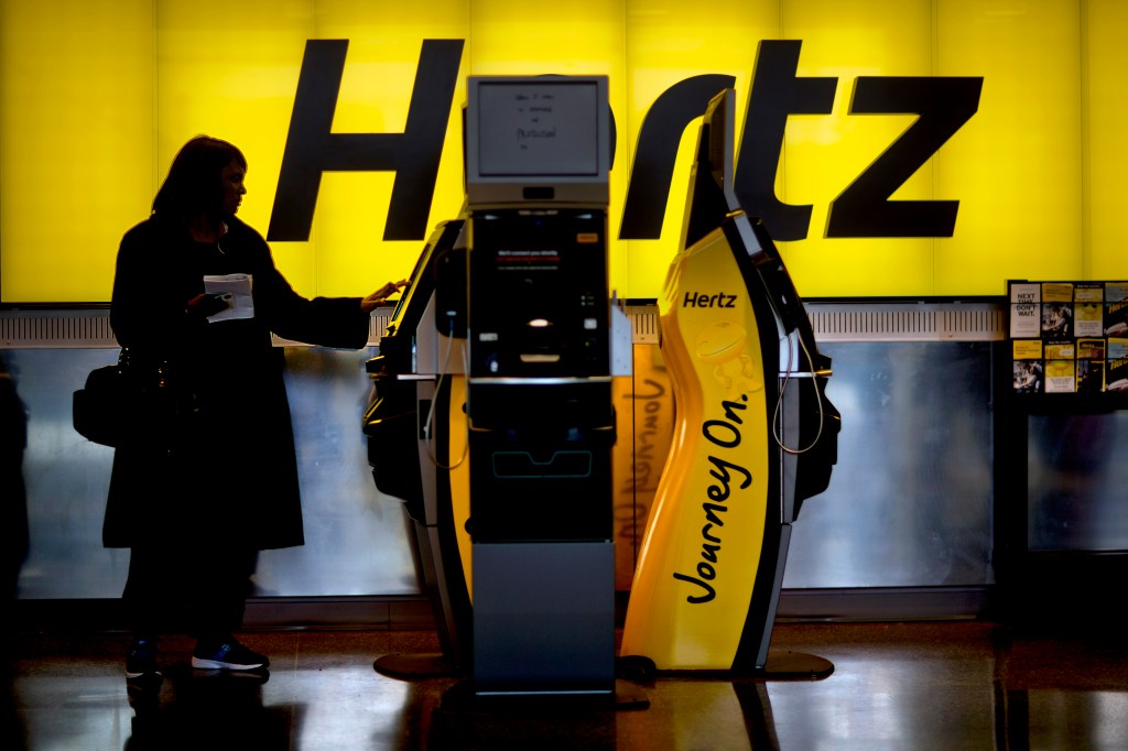 A customer checks in at a Hertz car rental counter at Hartsfield-Jackson Airport.