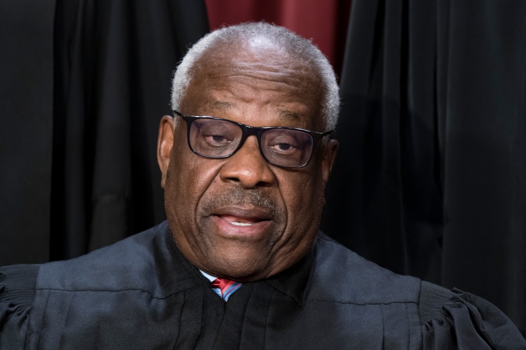 Associate Justice Clarence Thomas posing for a photo at the Supreme Court building in Washington, wearing a black robe