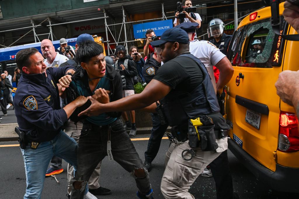 Cops struggle with a young man in street. 