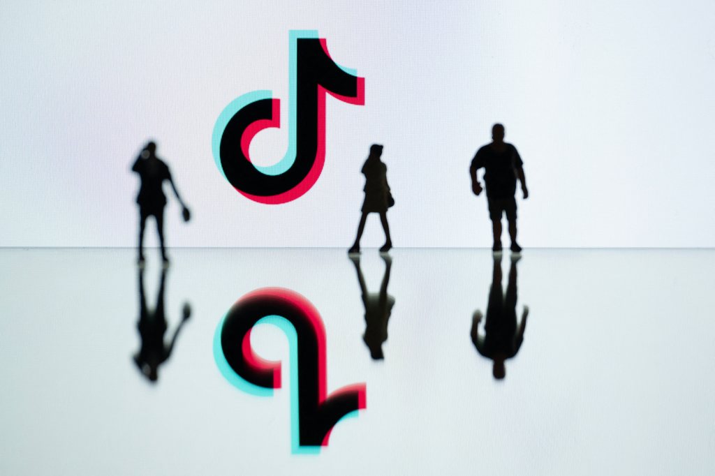 Figurines placed next to the logo of Tik Tok reflected in mirrors, taken in Mulhouse, eastern France on October 19, 2023