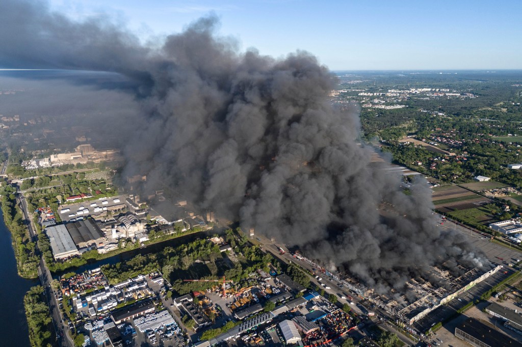 A fire burns from a vast shopping complex in Warsaw, Poland