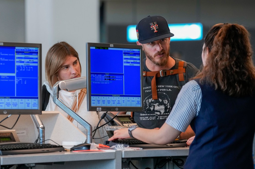 Passengers talking to ticketing agent.