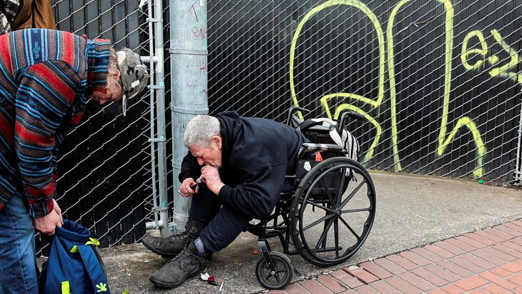 John Hood smokes methamphetamine with a friend outside a homeless shelter in downtown Portland, Oregon, U.S. February 9, 2024.