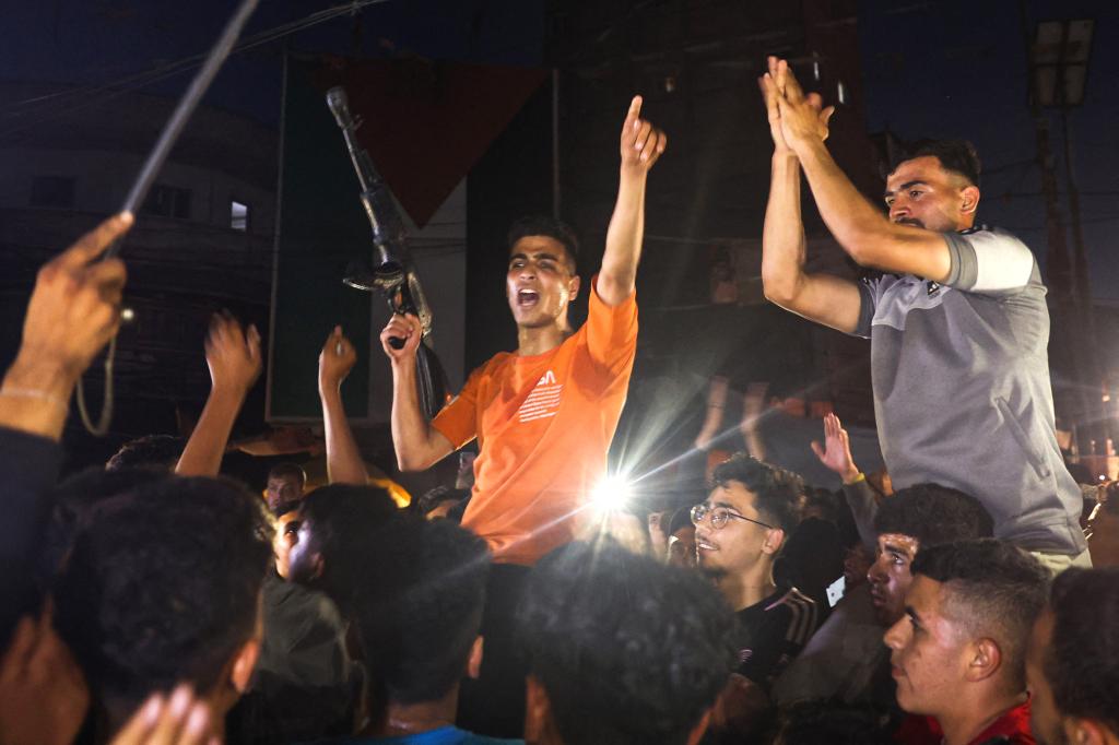 Palestinians celebrate in a street in Rafah, in the southern Gaza Strip, after Hamas announced it has accepted a truce proposal