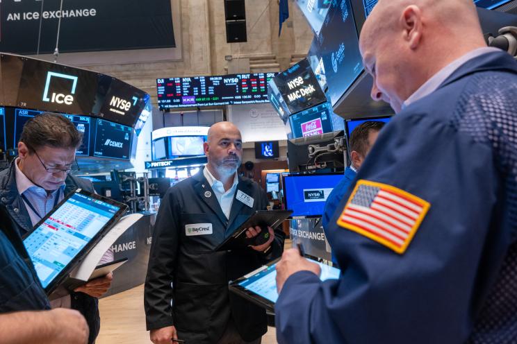 Traders working on the floor of the New York Stock Exchange as the Dow Jones surges over 400 points due to anticipated interest rate cuts