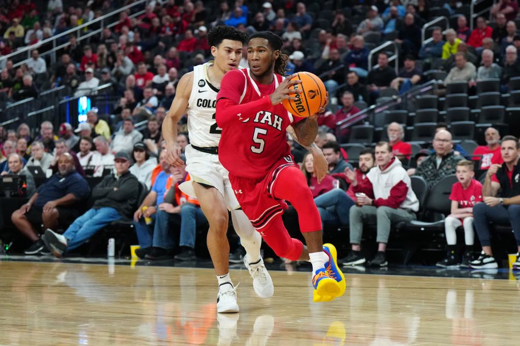 Utah Utes guard Deivon Smith driving to the basket against Colorado Buffaloes guard KJ Simpson during a basketball game at T-Mobile Arena