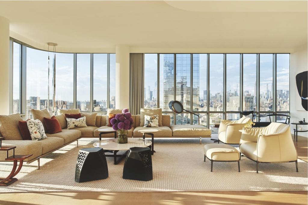 A luxurious living room with large windows in a condominium at 565 Broome St, S28A, Hudson Square, New York.