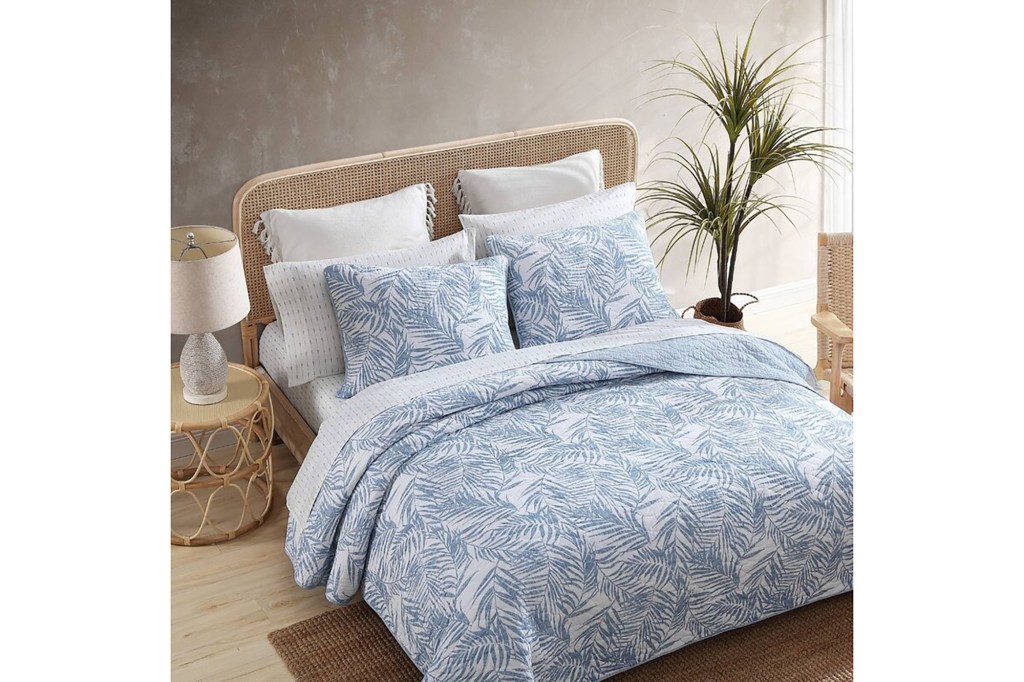 A bed with blue and white Tommy Bahama Palmday Cotton bedding