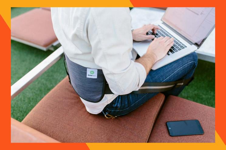 A person sitting on a chair using a laptop