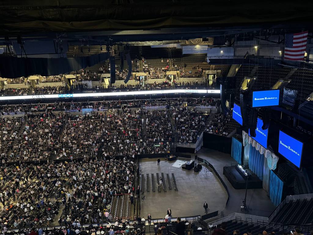 Large crowd of Berkshire Hathaway shareholders in a stadium, gathered to listen to Warren Buffett speak