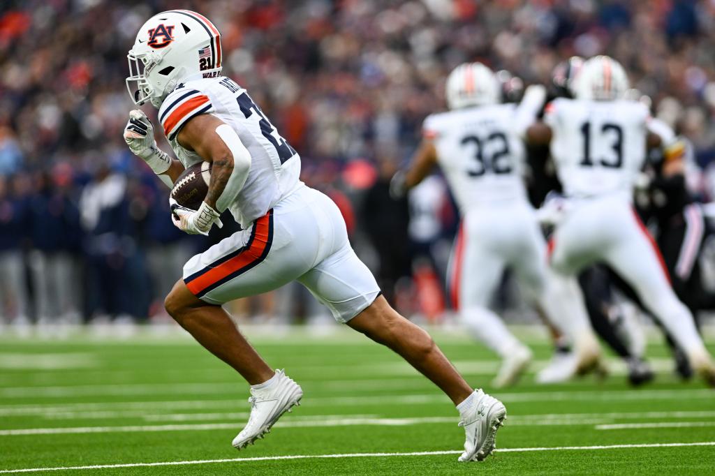 Brian Battie #21 of the Auburn Tigers runs the ball against the Maryland Terrapins in the first half of the TransPerfect Music City Bow at Nissan Stadium on December 30, 2023 in Nashville, Tennessee. 