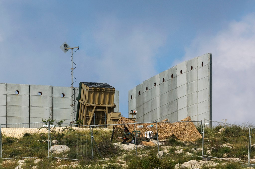 An Israeli soldier takes up a position in front of a battery of an Iron Dome air defence system near Jerusalem on April 15, 2024, amid the ongoing conflict.