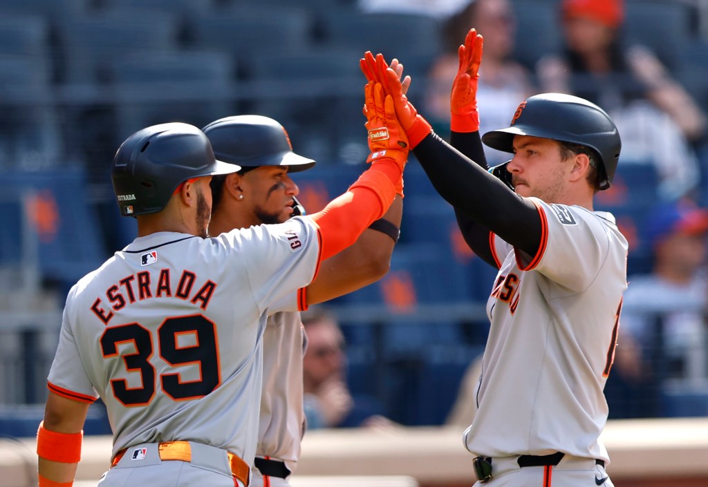 San Francisco Giants' Thairo Estrada (39), Luis Matos, center, and Patrick Bailey, right, celebrate after scoring during the 10th inning of a baseball game against the New York Mets