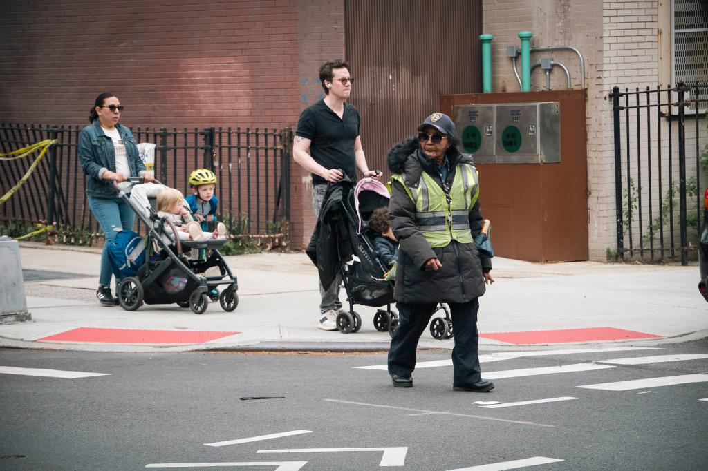 Maggie Poston crosses the street in Park Slope followed by two parents with strollers. 