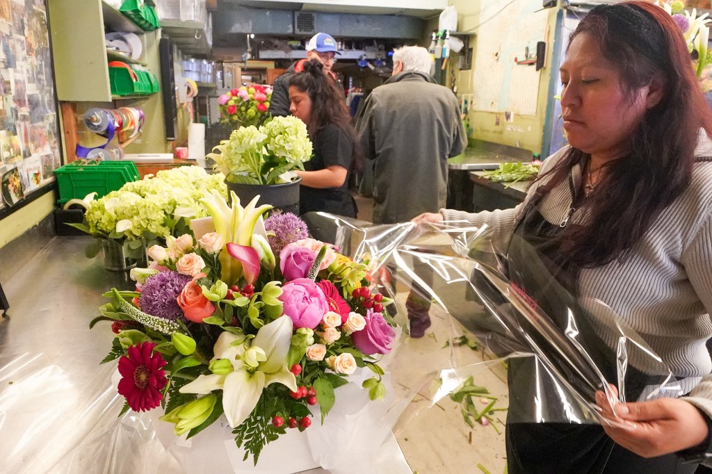 A worker wraps a Mother's Day arrangement. 