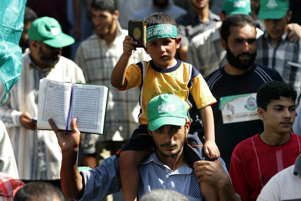 A Palestinian father and his son holding up copies of the Quran during a Hamas anti-Israel rally in the northern Gaza Strip on Sep. 29, 2006.