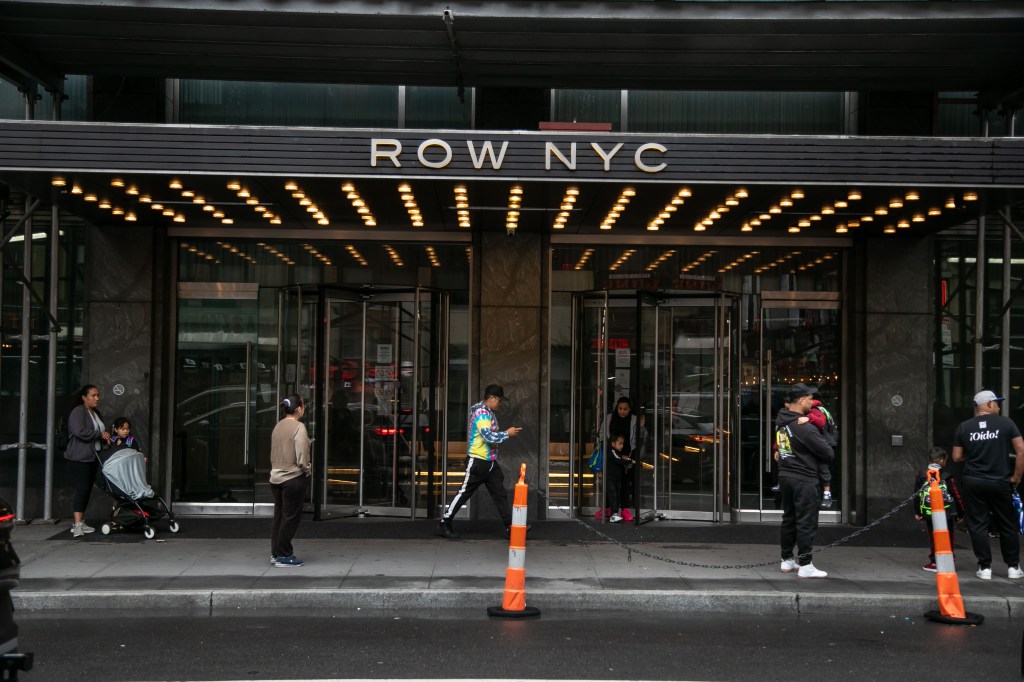 Pedestrians in front of the Row Hotel, currently a migrant shelter, in the Times Square neighborhood of New York City on Friday, May 10, 2024. 