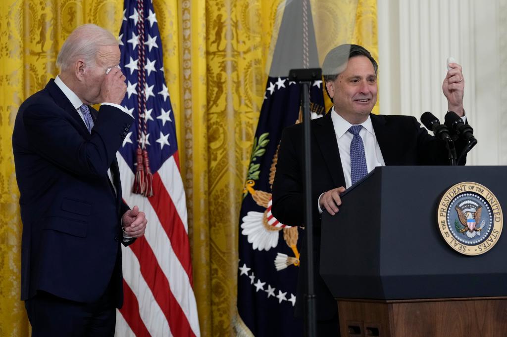 President Joe Biden wipes his eyes as outgoing White House chief of staff Ron Klain, holds up a rock, in the East Room of the White House in Washington, Wednesday, Feb. 1, 2023.