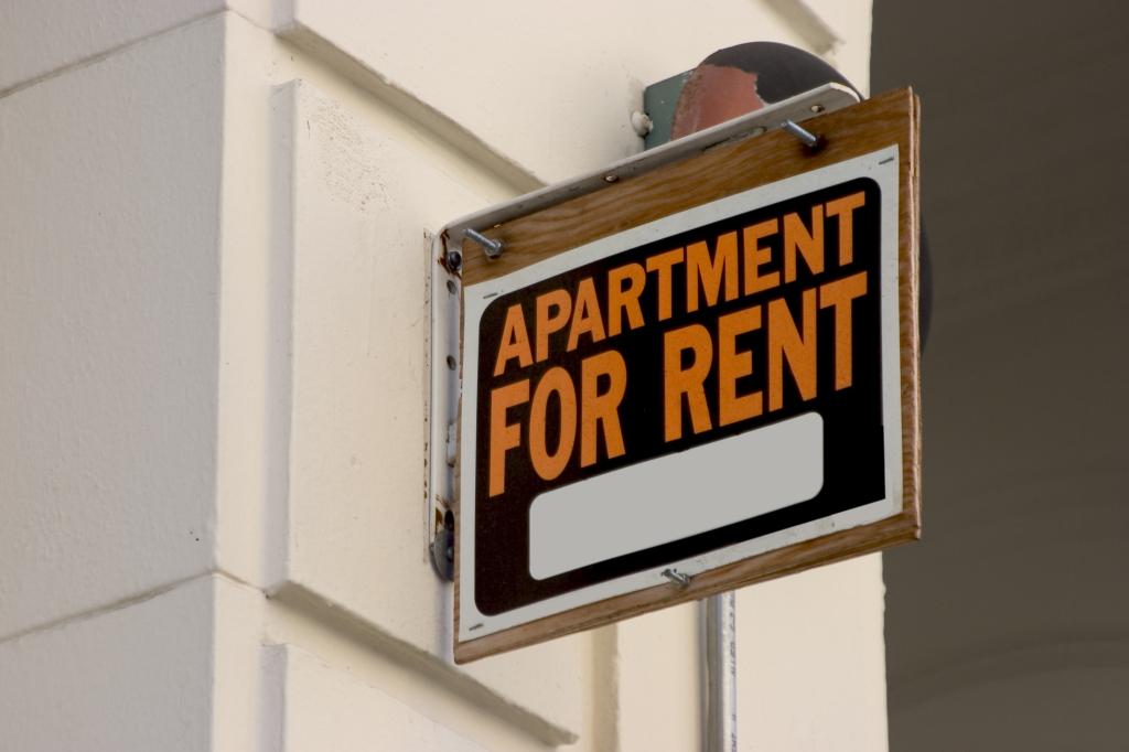 A for rent sign displayed on the side of a downtown apartment building