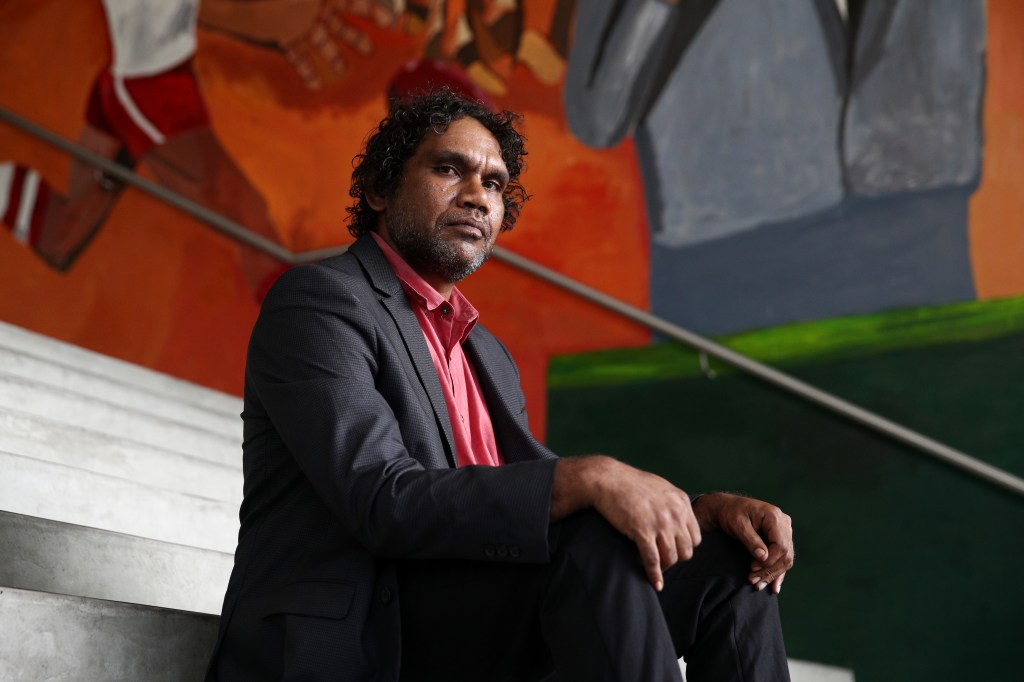 Vincent Namatjira poses in front of his  foyer wall commission at the  Museum of Contemporary Art on February 25, 2021.