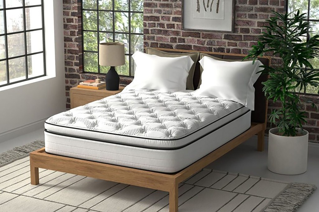 A bed with a wood frame and a white pillow