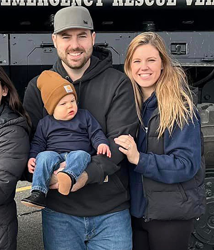 The Diller family poses in front of a helicopter.