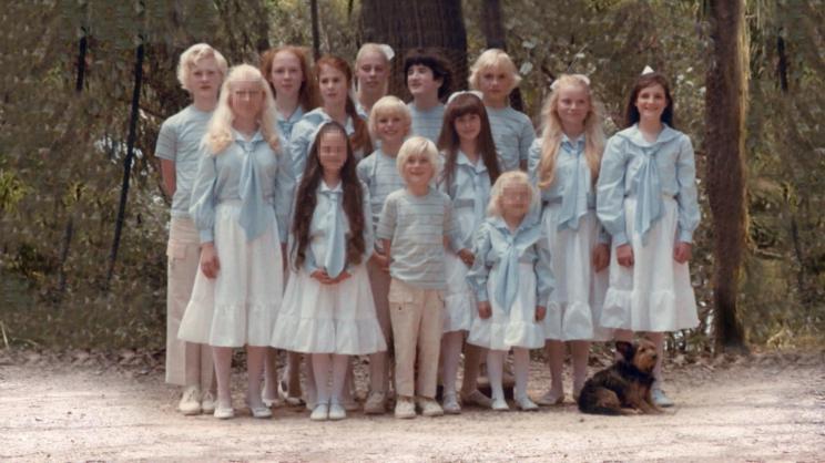 A group of people, part of the Australian sect 'The Family', posing together in matching outfits with dyed blonde hair in the 1990s