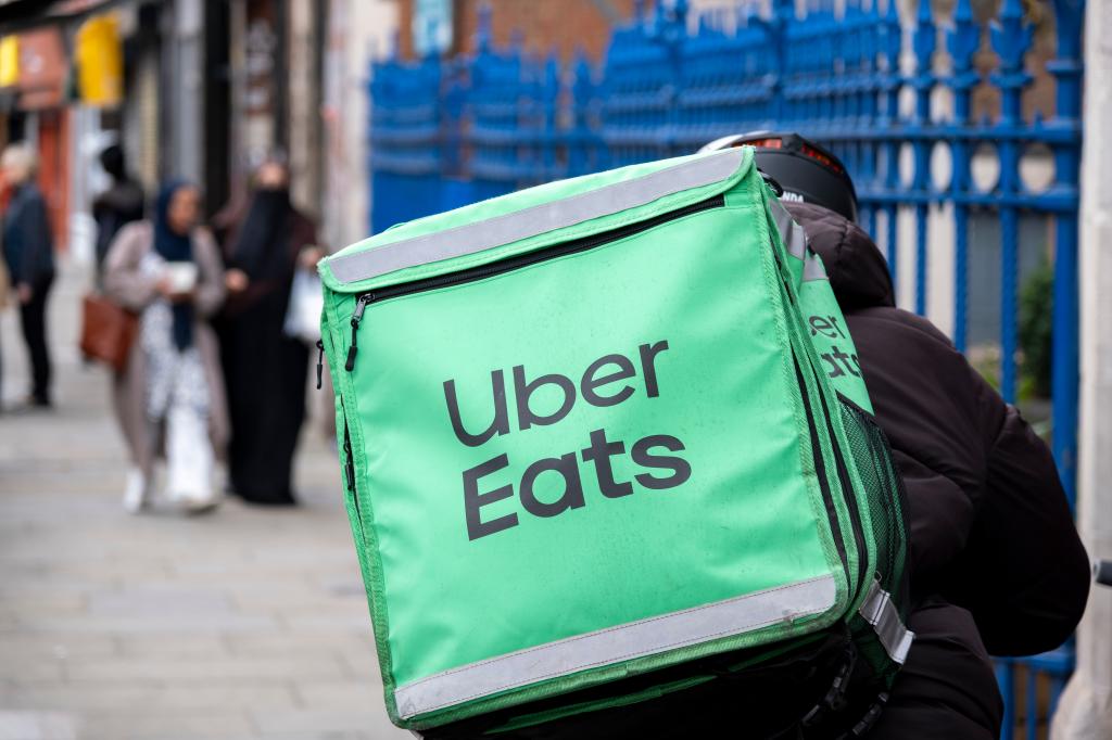 Uber Eats courier on a bike delivering food in Brick Lane, London