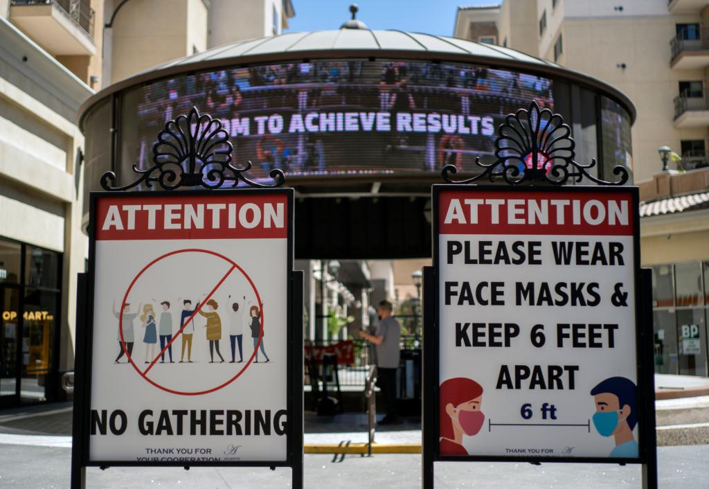 A sign urging people to mask and stay six feet apart.