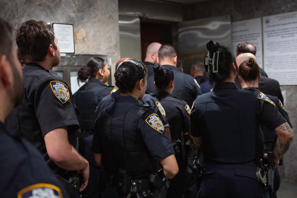 NYPD officers lined up to enter Queens Criminal Court for the arraignment.