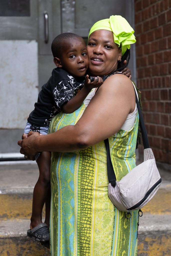 Wanda Shiver holding her son Dedjima-Yaw in Bronx, NY, as they navigate crime concerns near schools