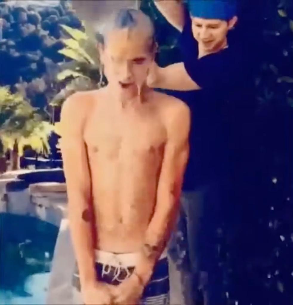 A man standing next to a pool in a scene from the 'Top Vine Ice Bucket Challenge' compilation video on YouTube.