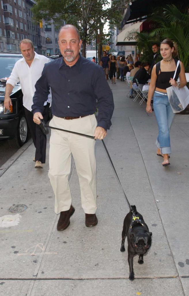 Billy Joel walks a black pug named Fenula on a New York street in 2002.