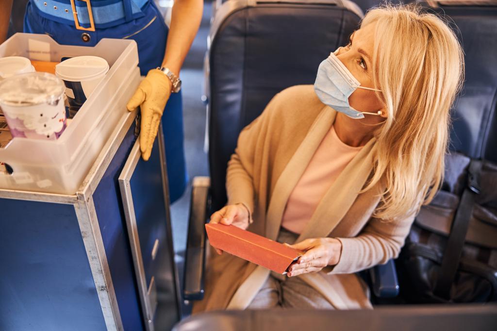 Passenger handing crew member trash.