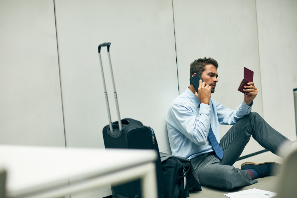 Flyer talking on phone in terminal.