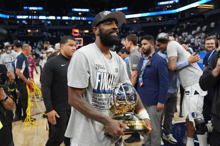 Dallas Mavericks guard Kyrie Irving holds the Western Conference Trophy after Game 5 of the Western Conference finals in the NBA basketball playoffs against the Minnesota Timberwolves, Thursday, May 30, 2024, in Minneapolis.