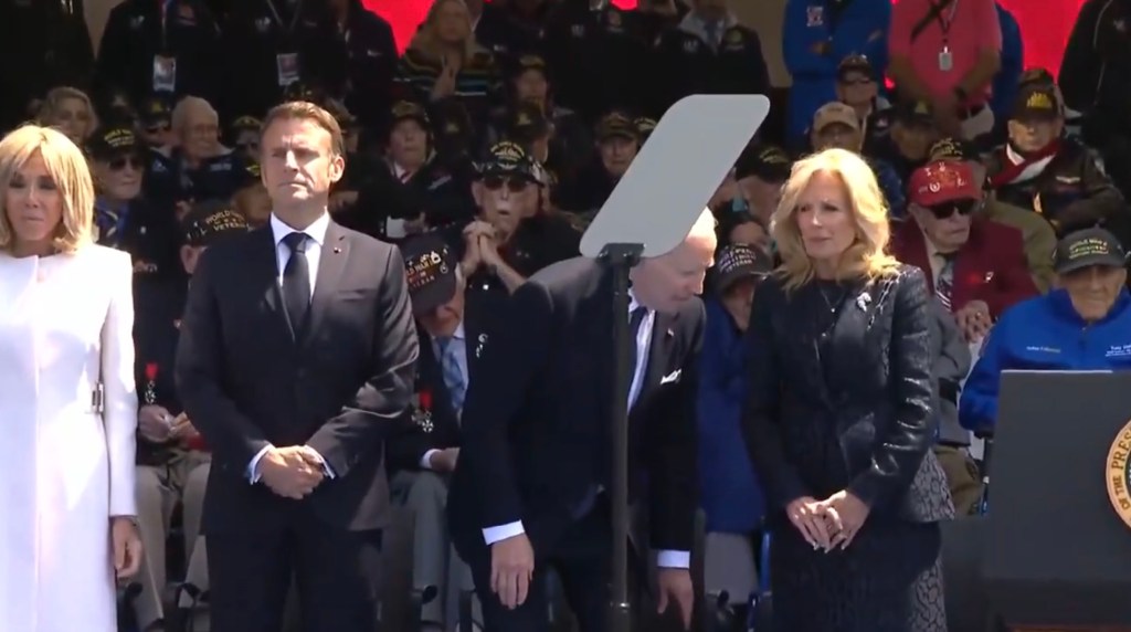 Emmanuel Macron and Jill Biden in a crowd, during a discussion about disputed viral videos related to President Biden on social media